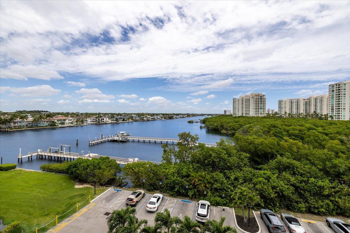 An elevated view of a parking lot, lush green trees, a dock, and a waterway — 3912 S Ocean Boulevard # 603, Highland Beach FL 33487, HIGHLAND BEACH, FL