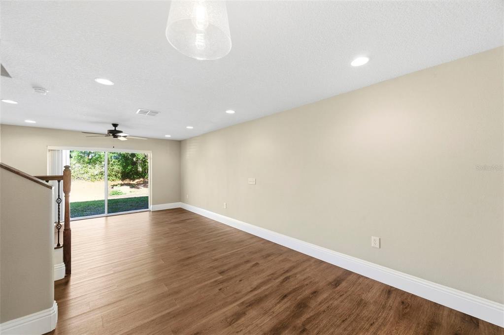 An empty room with wood-look flooring, recessed lighting, a ceiling fan, and sliding glass doors — 6811 DARTMOUTH HILL STREET, RIVERVIEW, FL