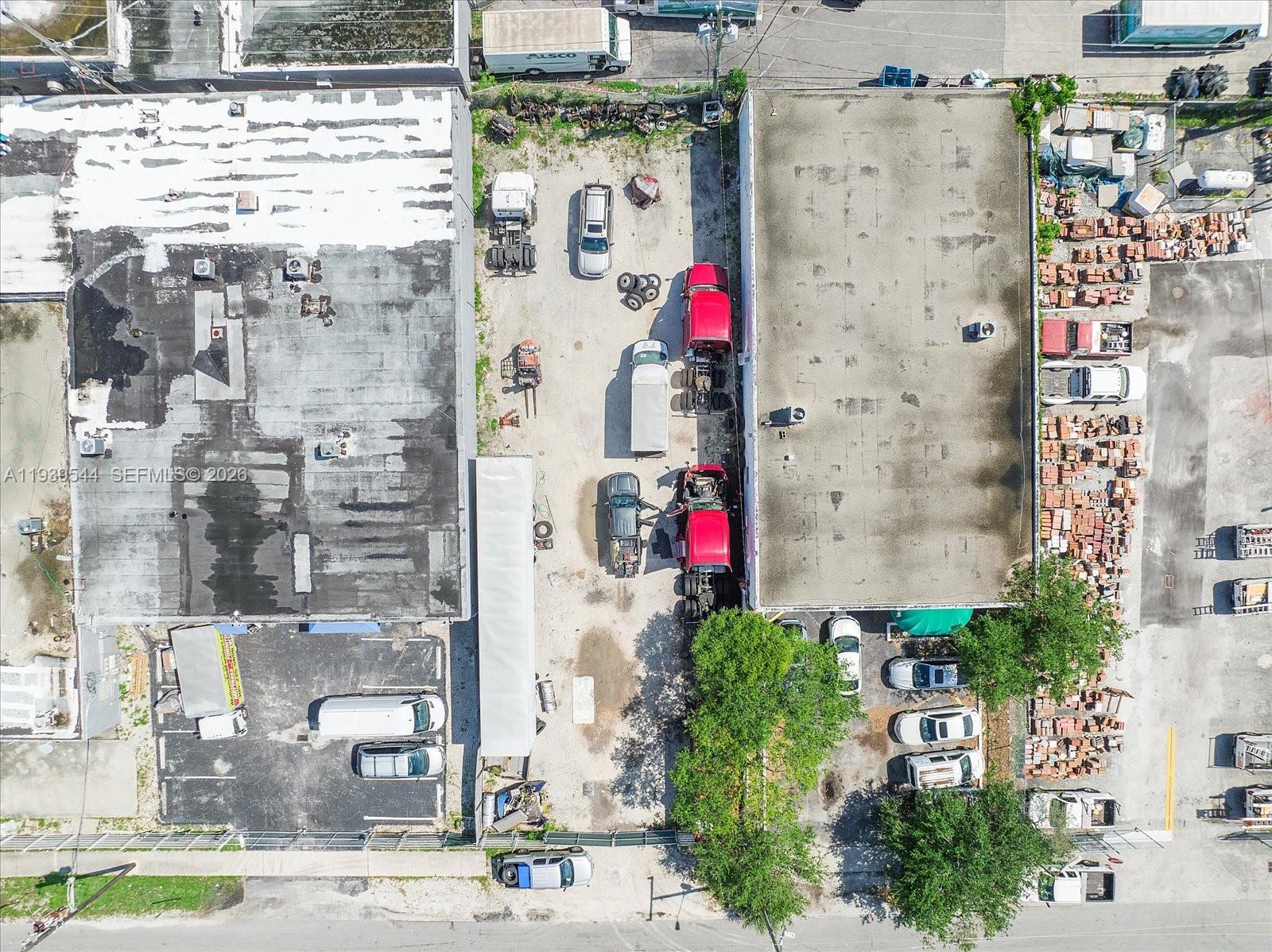 An aerial view shows two commercial buildings separated by a gravel lot containing parked vehicles — Grant St, Hollywood FL 33020, HOLLYWOOD, FL