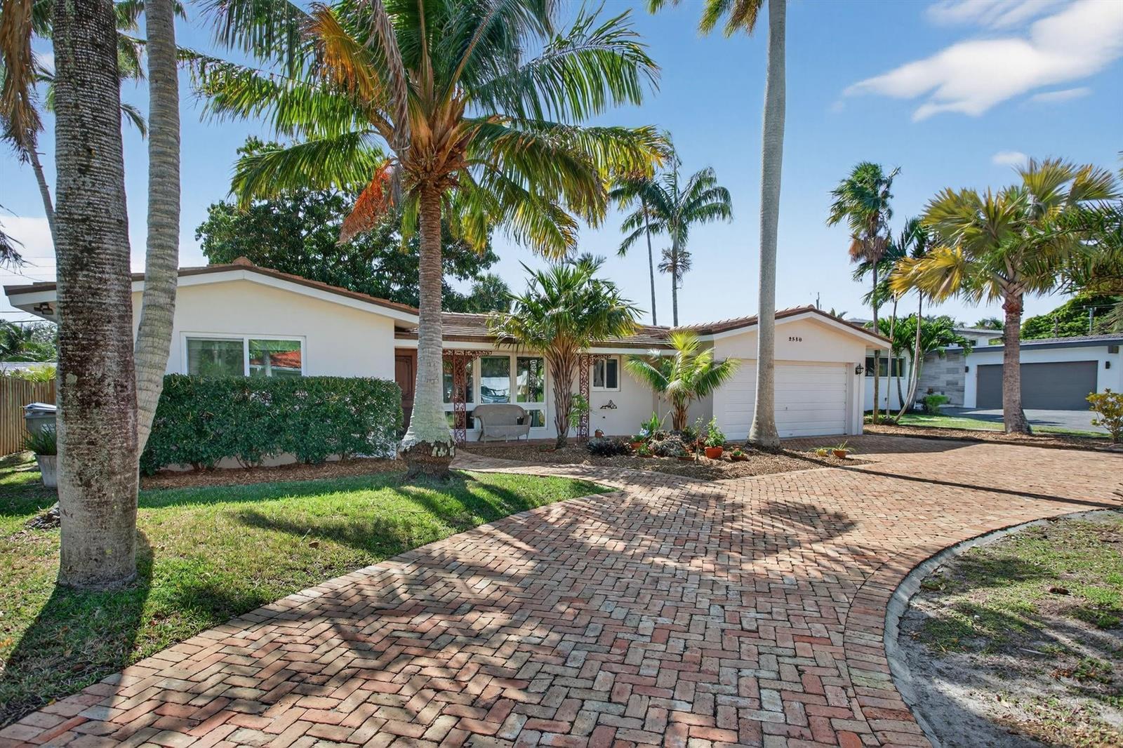 An aerial view of a single-story house with a brick driveway and palm trees — 2580 SE 5th Court, Pompano Beach FL 33062, POMPANO BEACH, FL