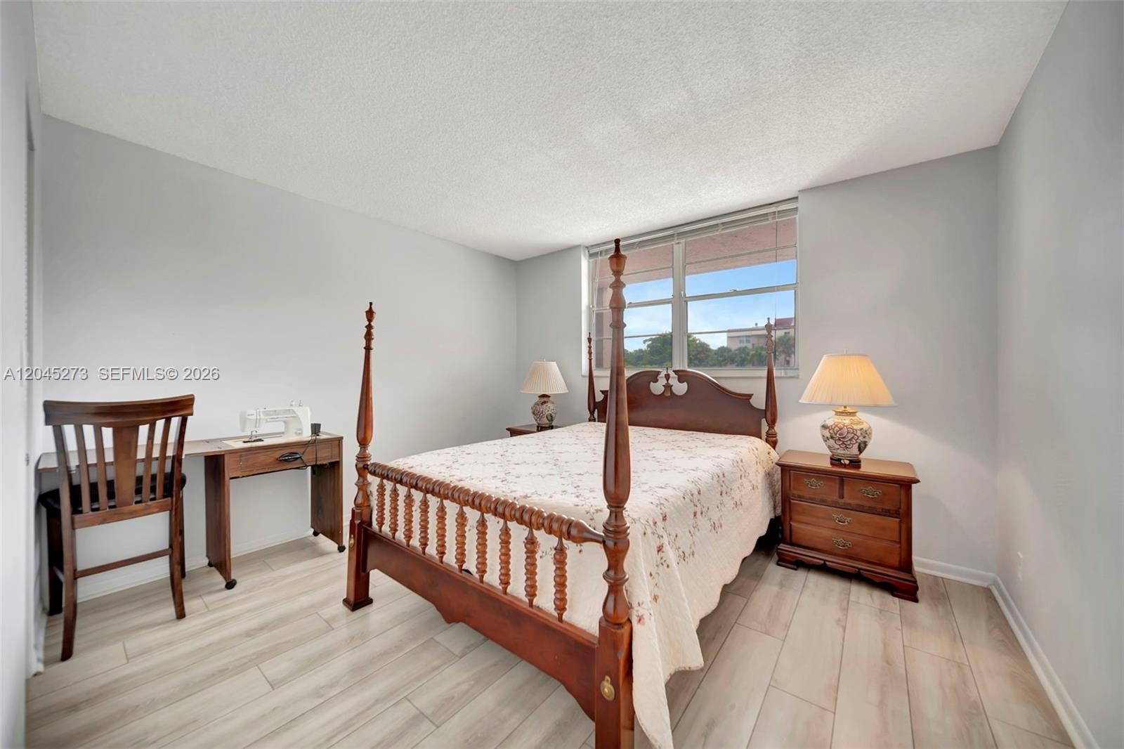 A bedroom features a wooden four-poster bed, two nightstands, a desk with a chair, and light-colored flooring — 2571 Aragon Blvd # 220, Sunrise FL 33322, SUNRISE, FL