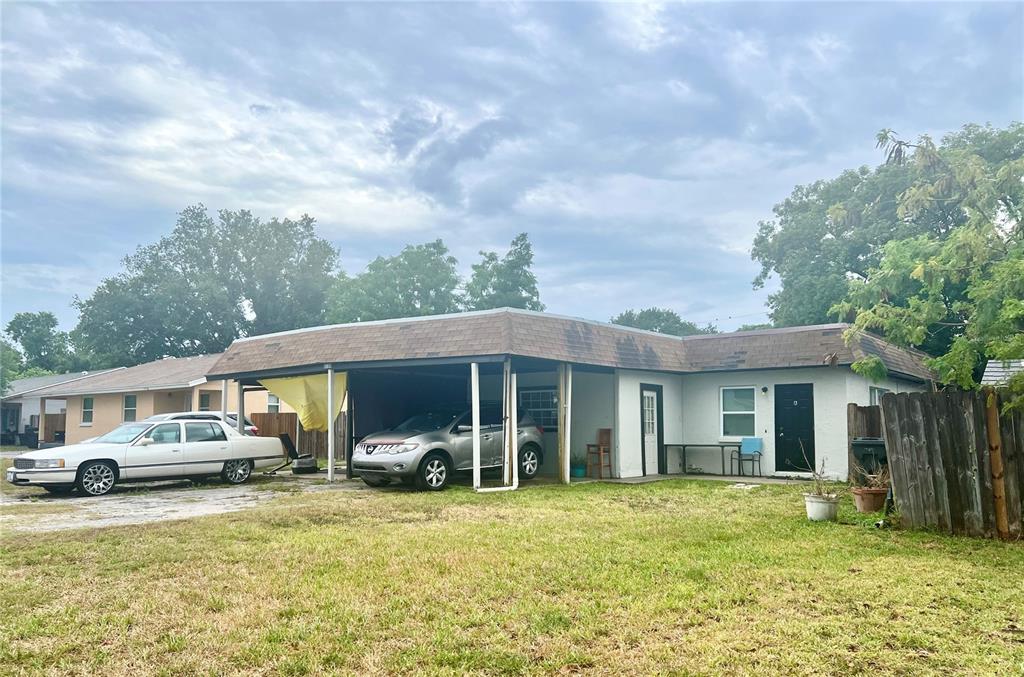 A single-story house with a carport, two parked cars, and a grassy front yard — 4130 32ND STREET N, ST PETERSBURG, FL