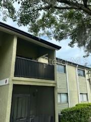 Exterior view of a two-story apartment building with a screened-in balcony and ground-level patio — 914 LAKE DESTINY ROAD UNIT H, ALTAMONTE SPRINGS, FL