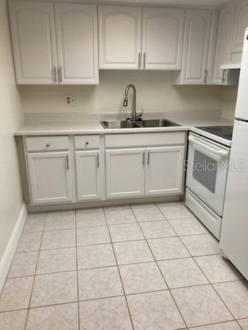 A kitchen with white cabinets, a stainless steel sink, and light-colored tile flooring — 914 LAKE DESTINY ROAD UNIT H, ALTAMONTE SPRINGS, FL