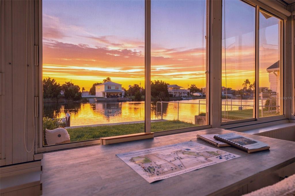 A view of a sunset over a canal from a sunroom with a desk — 3339 POINSETTIA DRIVE, HERNANDO BEACH, FL
