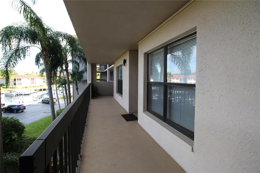 A covered balcony with a metal railing overlooks a parking lot and a marina — 1806 MARINER DRIVE UNIT 214, TARPON SPRINGS, FL