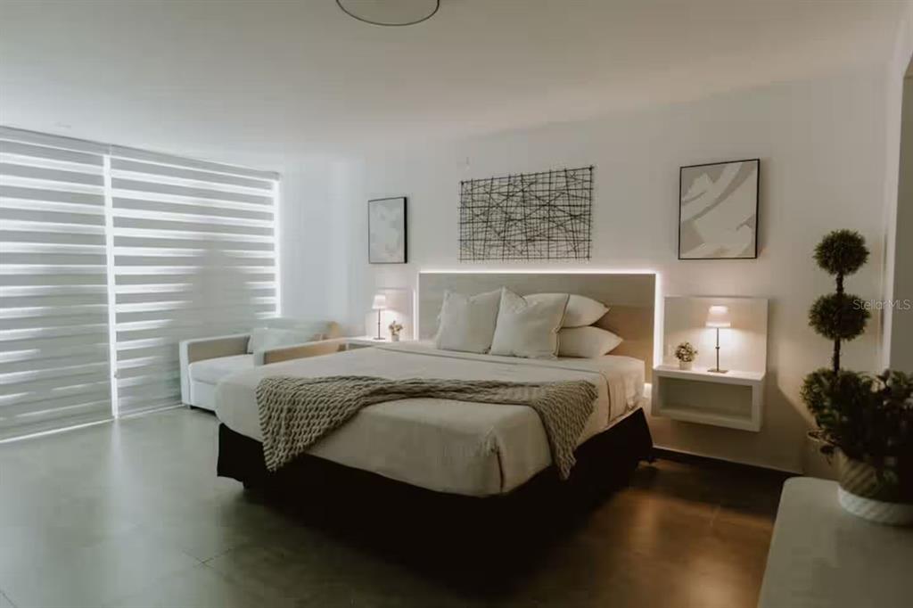 A modern bedroom features a king bed with backlighting, floating nightstands, and large window blinds — 6165 AV. ISLA VERDE UNIT 1052, CAROLINA, PR