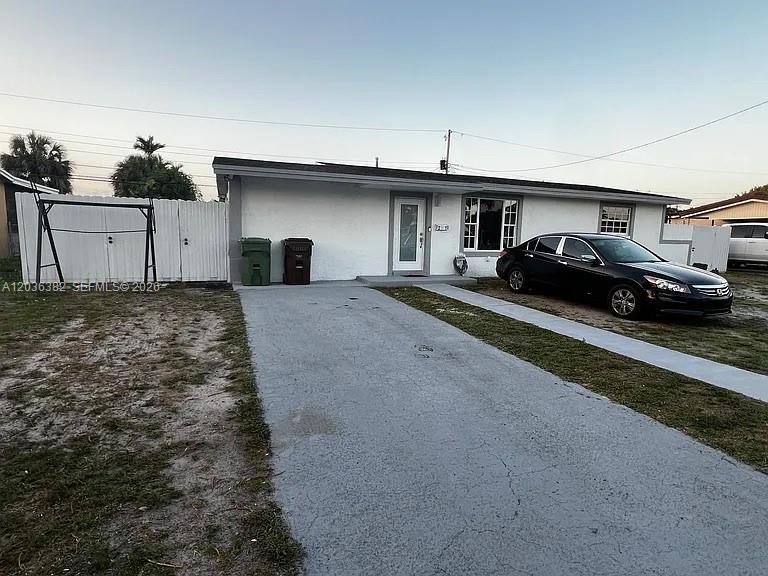 A single-story white house with a driveway and a black sedan parked in front — 1271 W 79th St, Hialeah FL 33014, HIALEAH, FL