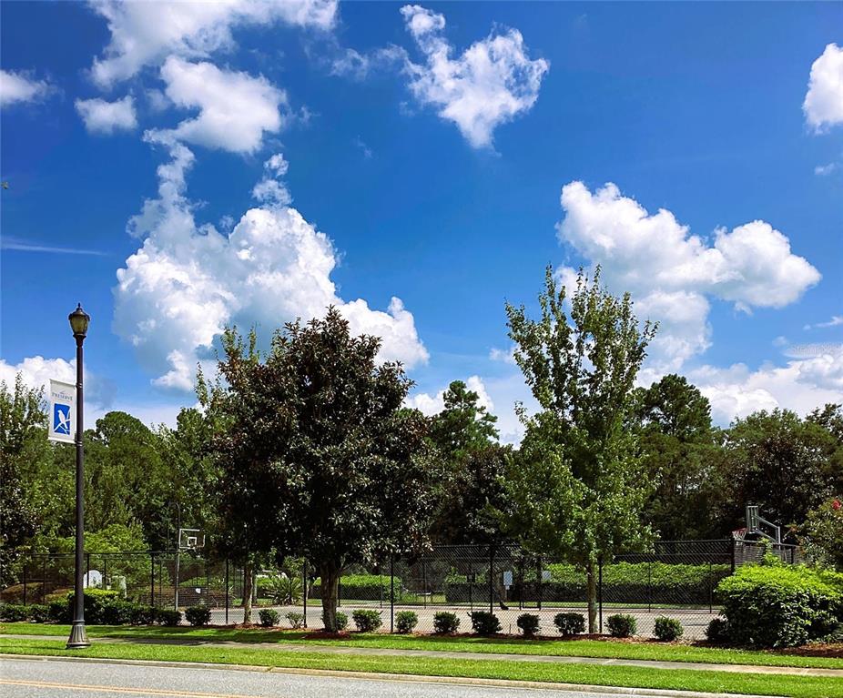 A street view shows a fenced tennis court behind trees and a lamp post — 149 SW BELLFLOWER DRIVE, LAKE CITY, FL