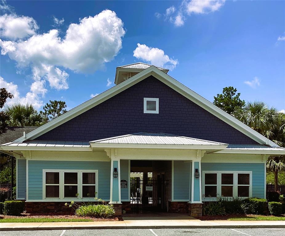 A blue building with a gabled roof and a covered entryway stands under a sky — 149 SW BELLFLOWER DRIVE, LAKE CITY, FL