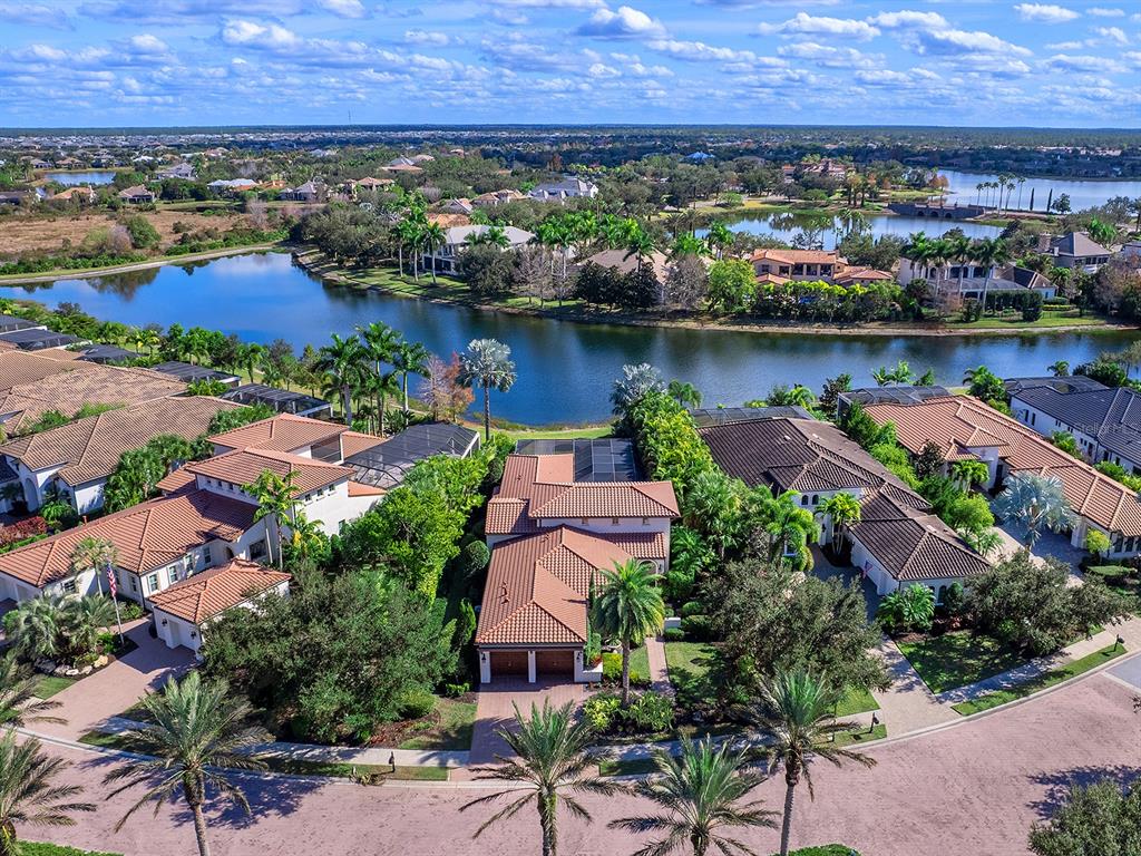 An aerial view shows several houses with tiled roofs situated along a lake in Florida — 7951 MATERA COURT, LAKEWOOD RANCH, FL