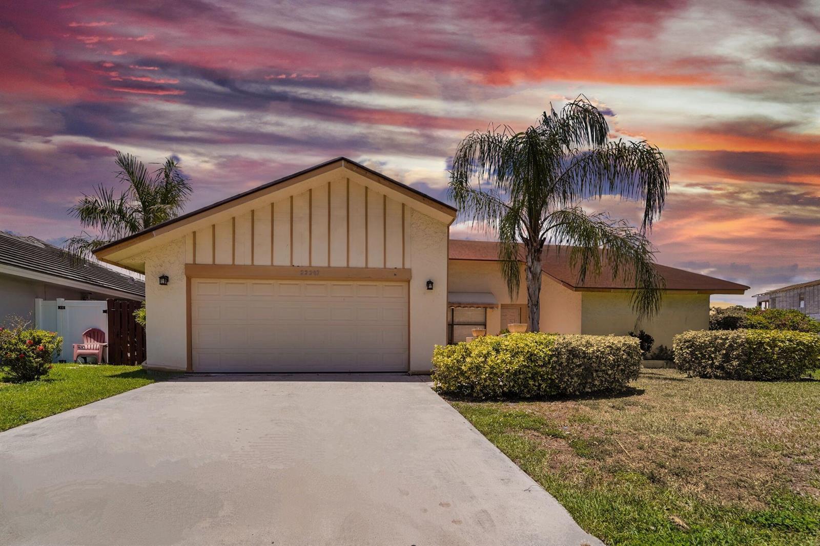A single-story house with a beige stucco exterior, a two-car garage, and a palm tree — 22207 Alyssum Way, Boca Raton FL 33433, BOCA RATON, FL