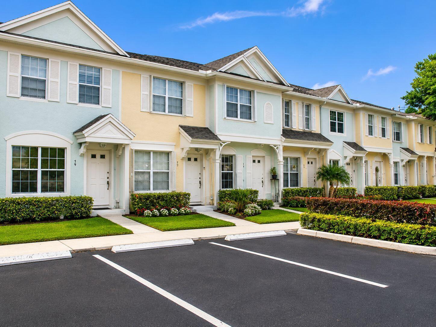A row of colorful two-story townhouses with white trim and a paved parking lot in front — 75 Whitehead Circle # 75, Weston FL 33326, WESTON, FL