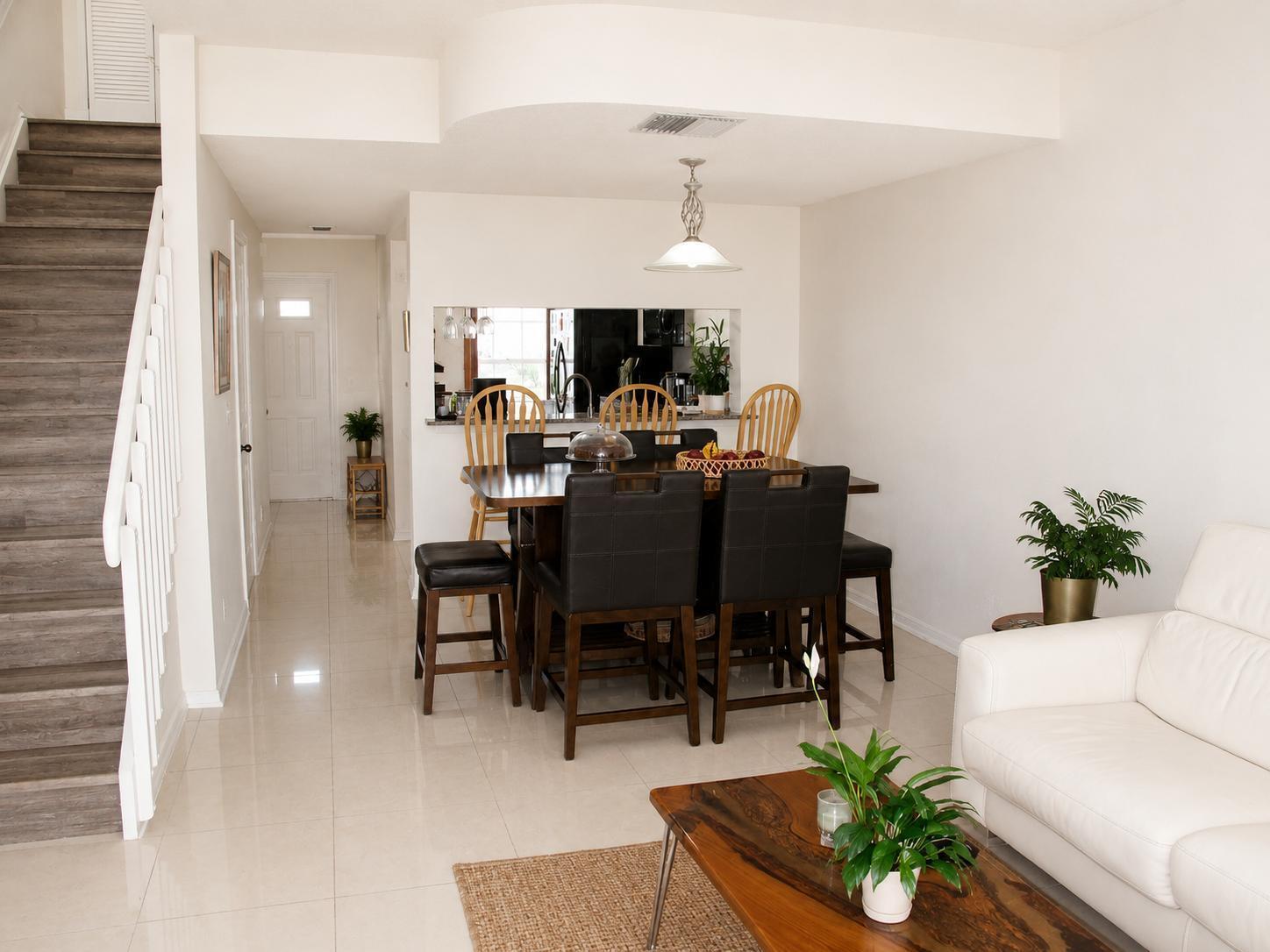 A dining area with a dark wood table and chairs sits beside a white sofa — 75 Whitehead Circle # 75, Weston FL 33326, WESTON, FL