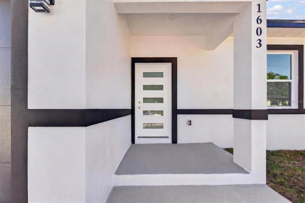 The exterior of a house features a white front door with horizontal glass panels — 1603 WRIGHT DRIVE, LAKELAND, FL