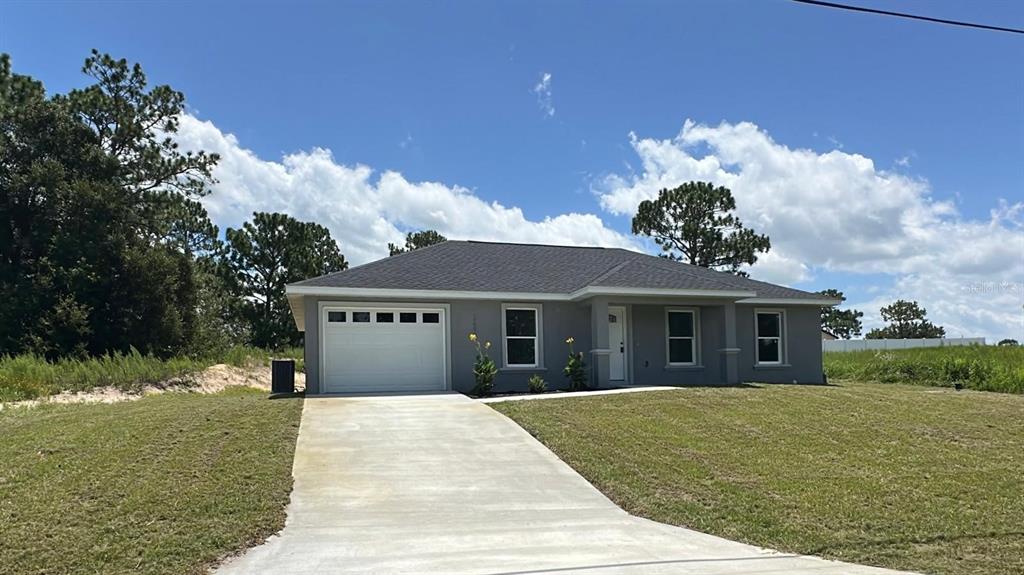 A single-story gray house with a white garage door and a concrete driveway — 2691 SW 148TH COURT, OCALA, FL