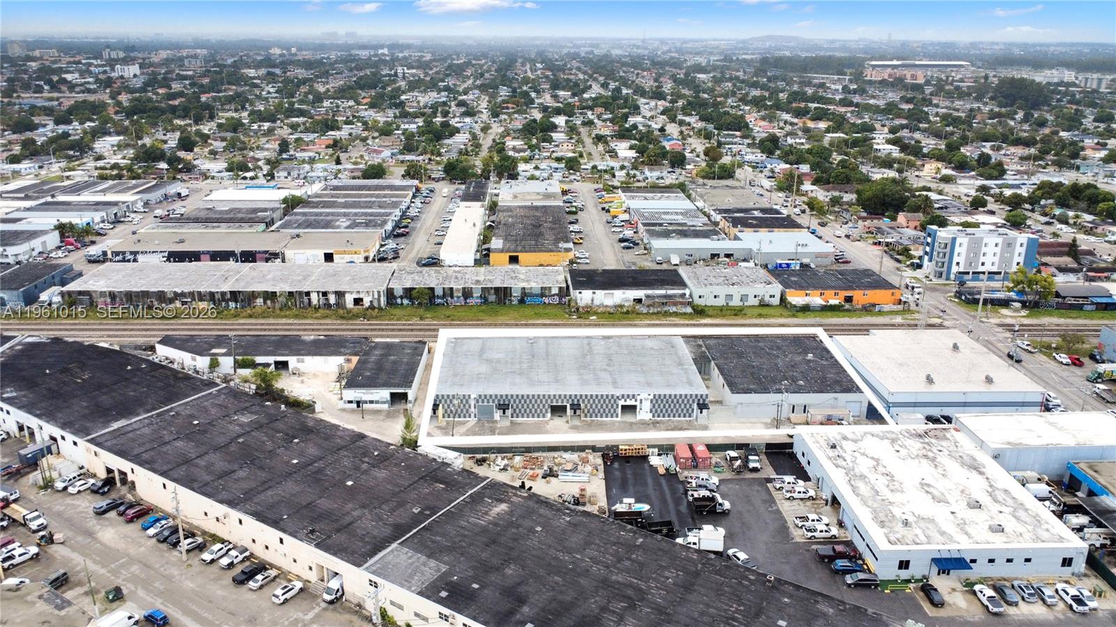 An aerial view shows several industrial warehouse buildings with parking lots and surrounding urban development — 7000 NW 37th Ct, Hialeah FL 33147, HIALEAH, FL
