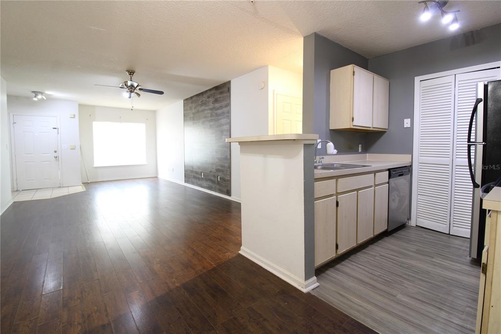 A kitchen with light wood cabinets and a dishwasher opens into a living area — 4348 S KIRKMAN ROAD UNIT 813, ORLANDO, FL
