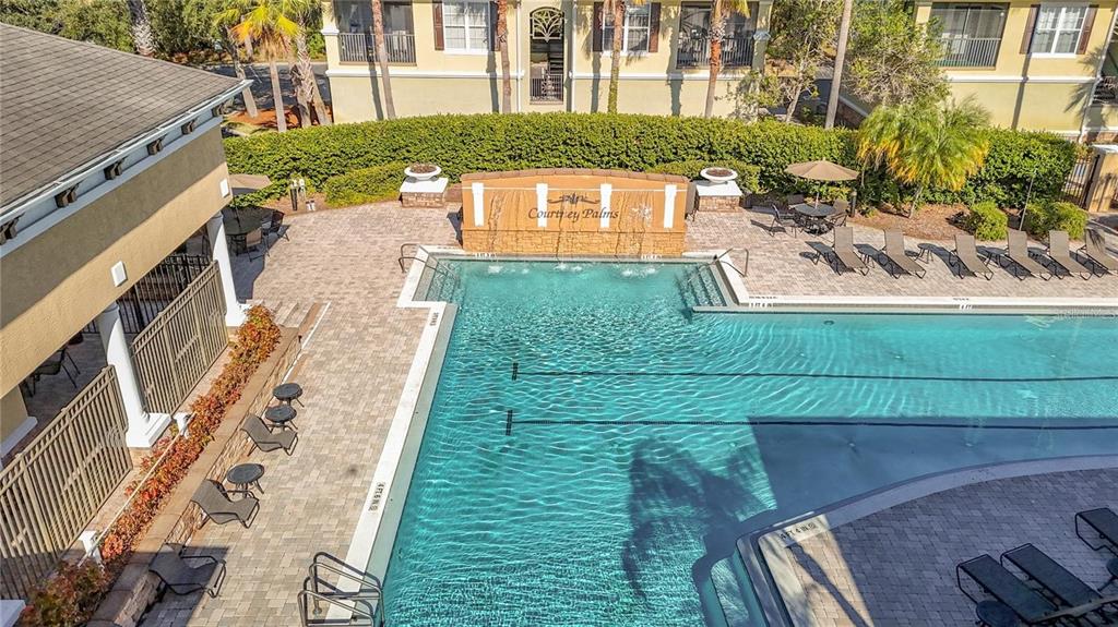 An aerial view of a swimming pool with a water feature at an apartment complex — 10025 COURTNEY PALMS BOULEVARD UNIT 204, TAMPA, FL