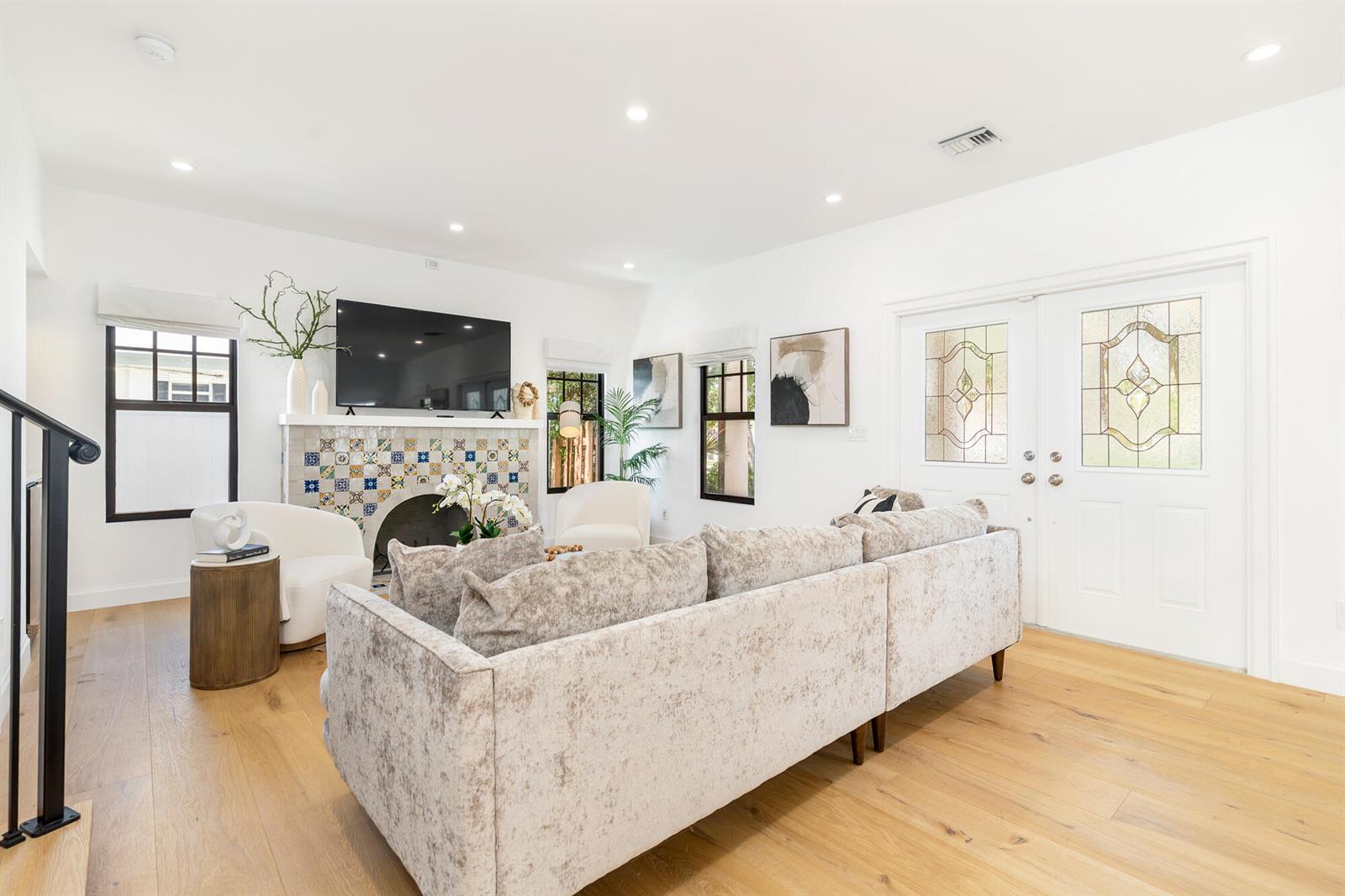 A living room features a tiled fireplace, a large sectional sofa, and light wood flooring — 254 9th Street, West Palm Beach FL 33401, WEST PALM BEACH, FL