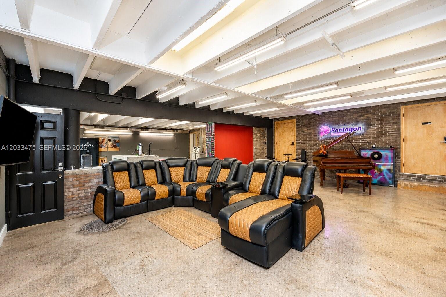 A basement recreation room features a sectional sofa, a grand piano, and exposed ceiling beams — 7025 NW 7th Ave, Miami FL 33150, MIAMI, FL