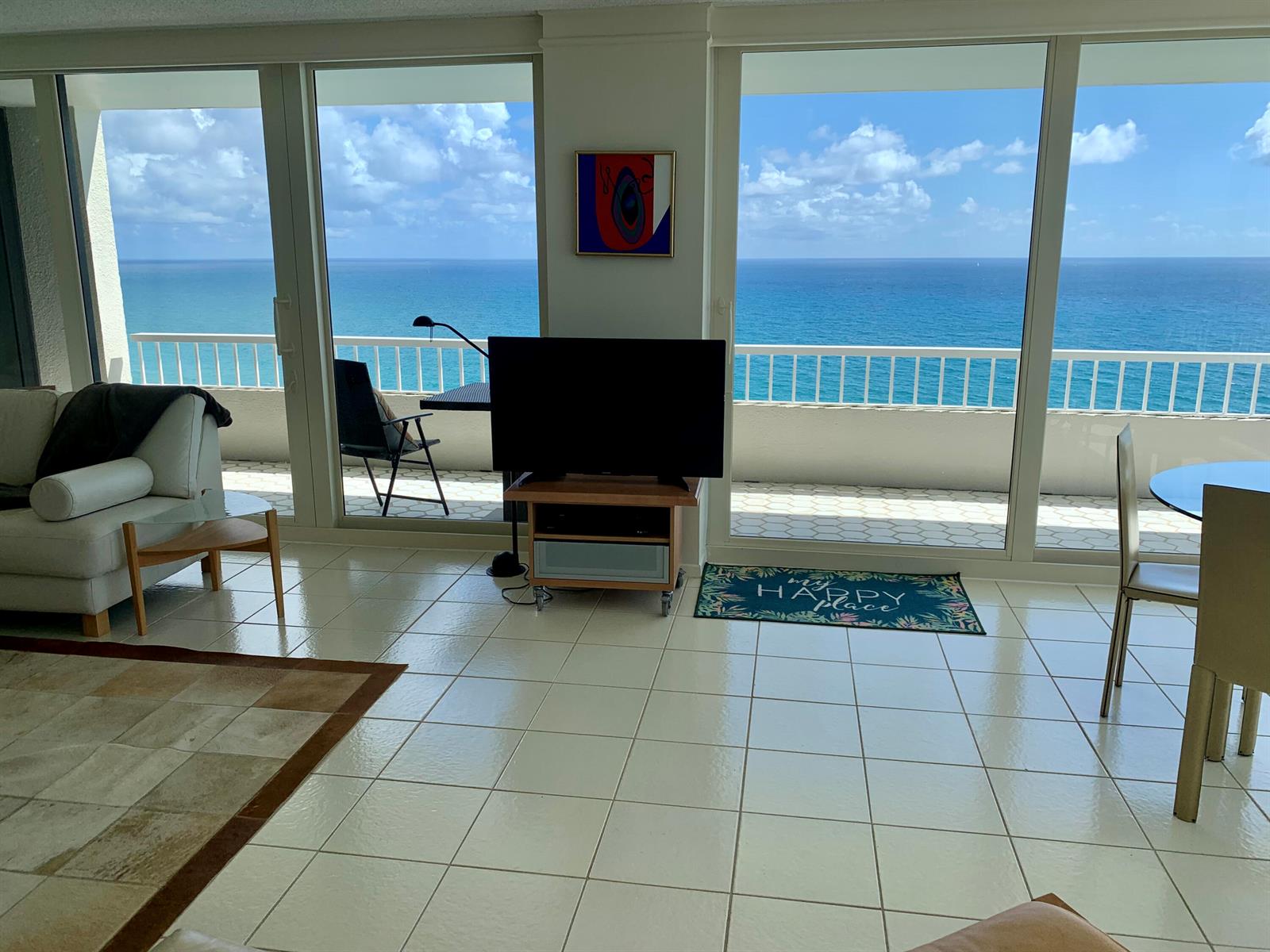 A living room with tile floors and floor-to-ceiling windows overlooking the ocean — 5540 N Ocean Drive # a, Riviera Beach FL 33404, RIVIERA BEACH, FL