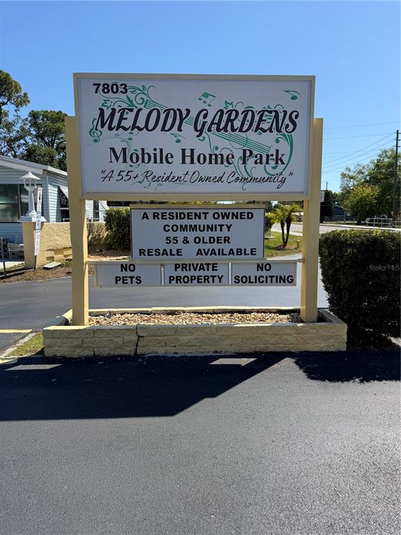 A sign for Melody Gardens Mobile Home Park stands above a low brick planter — 7803 46TH AVENUE N UNIT 129, ST PETERSBURG, FL