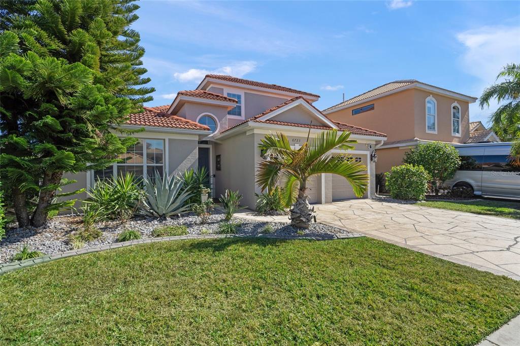A two-story house with a tile roof, a stone driveway, and a landscaped front yard — 6723 TAILFEATHER WAY, BRADENTON, FL