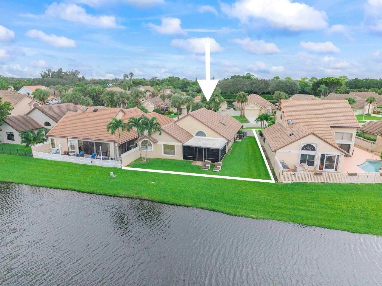 An aerial view of a suburban house with a screened patio and backyard facing water — 6852 Bitterbush Place, Boynton Beach FL 33472, BOYNTON BEACH, FL