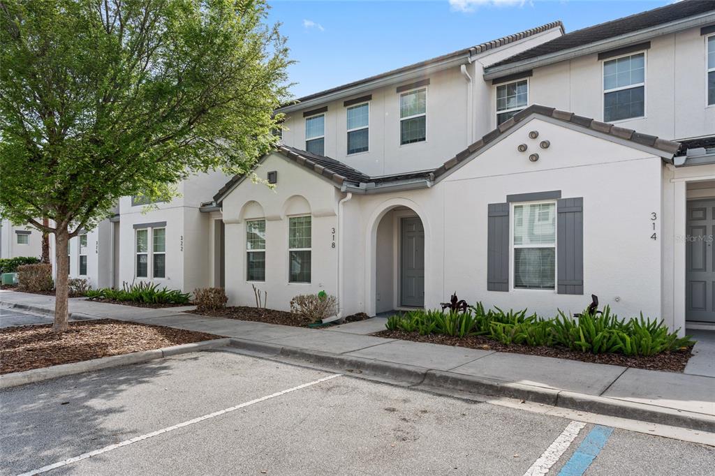 A row of two-story townhomes with white stucco exteriors and gray shutters — 318 CAPTIVA DRIVE, DAVENPORT, FL