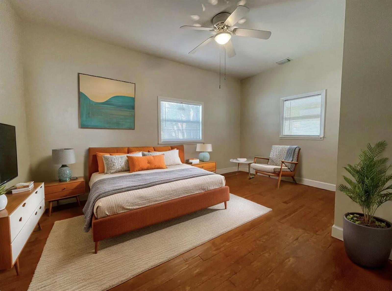 A bedroom features a mid-century modern bed, wood floors, and two windows with blinds — 1969 NE 4th Street, Deerfield Beach FL 33441, DEERFIELD BEACH, FL
