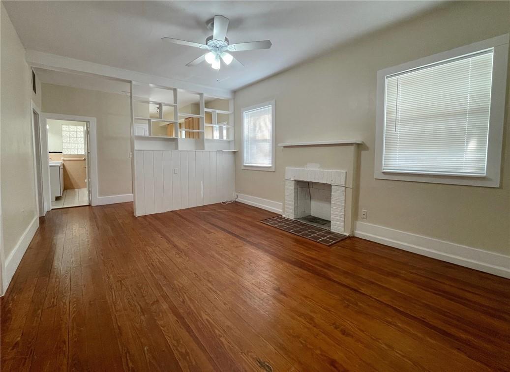 A living room features hardwood floors, a white brick fireplace, and a built-in room divider — 1969 NE 4th Street, Deerfield Beach FL 33441, DEERFIELD BEACH, FL
