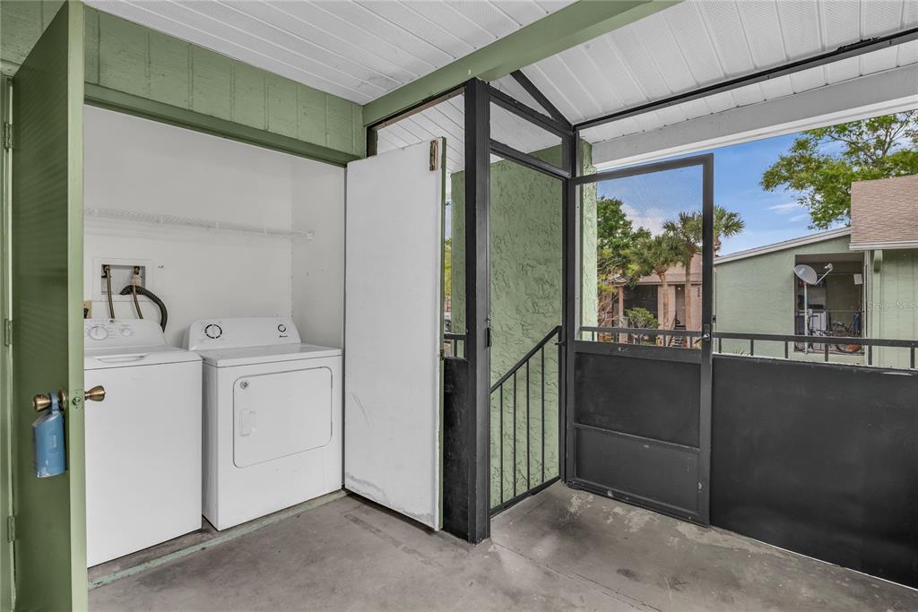 A laundry area with a washer and dryer located on a covered outdoor patio — 4830 S SEMORAN BOULEVARD UNIT 1108, ORLANDO, FL