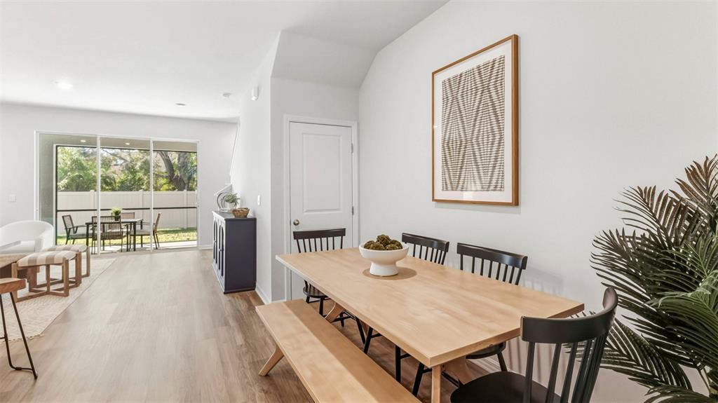 A dining area with a wooden table and bench sits beside a sliding glass door — 4052 GOLD DUST LANE, SARASOTA, FL