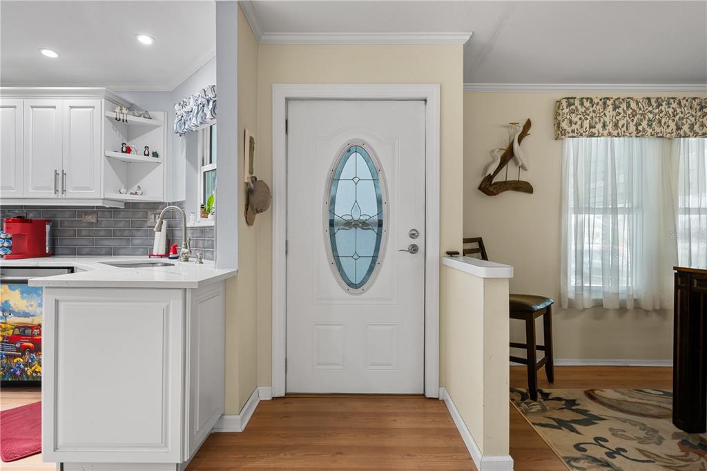 An entryway features a white front door with an oval window, adjacent to a kitchen — 8433 REGAL WAY, PALMETTO, FL