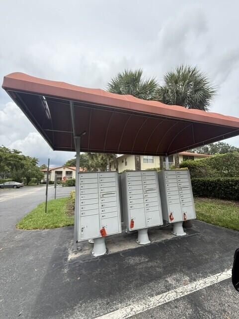 A row of three outdoor metal mailbox units stands under a large, reddish-brown fabric awning — 3031 Holiday Springs Boulevard # 7, Margate FL 33063, MARGATE, FL