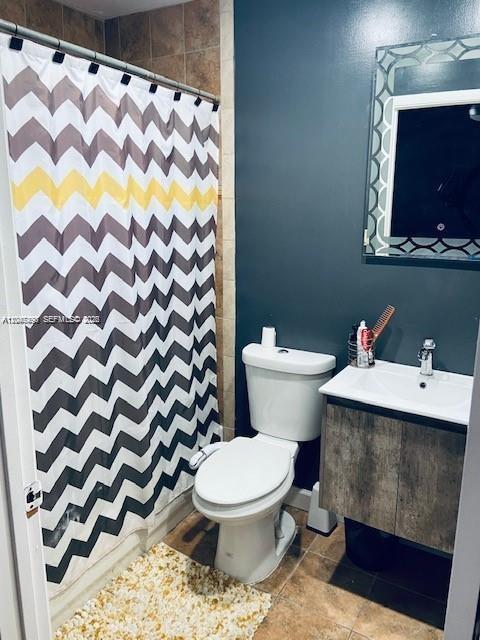 A bathroom features a chevron shower curtain, a white toilet, and a wood-look vanity — 8075 NW 8th St # 6, Miami FL 33126, MIAMI, FL