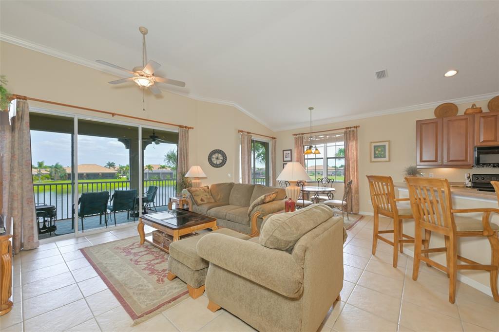 A living room with tile floors, a ceiling fan, and a sliding door to a patio — 1330 EMERALD DUNES DRIVE, SUN CITY CENTER, FL
