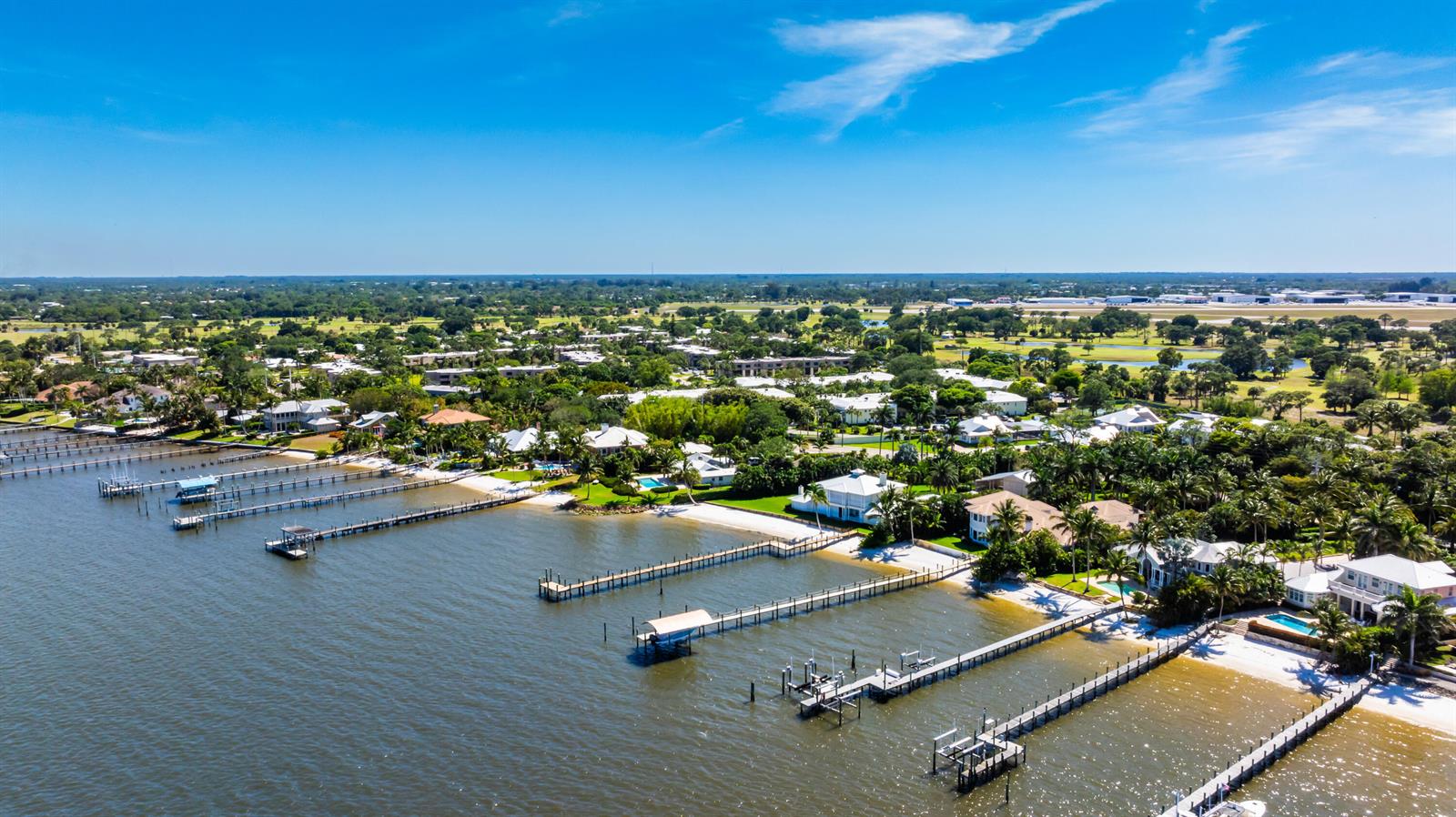 An aerial view shows waterfront homes with private docks along a sandy shoreline — 1600 SE Saint Lucie Boulevard # 205, Stuart FL 34996, STUART, FL