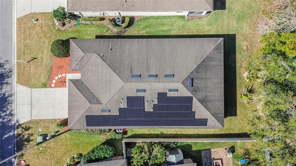 An aerial view shows a residential house roof with solar panels and several skylights — 2819 HOLLY BLUFF COURT, PLANT CITY, FL