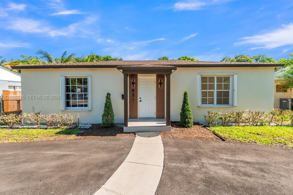 A single-story house with a white exterior, a covered entryway, and a paved driveway — 831 NE 128th St, North Miami FL 33161, NORTH MIAMI, FL
