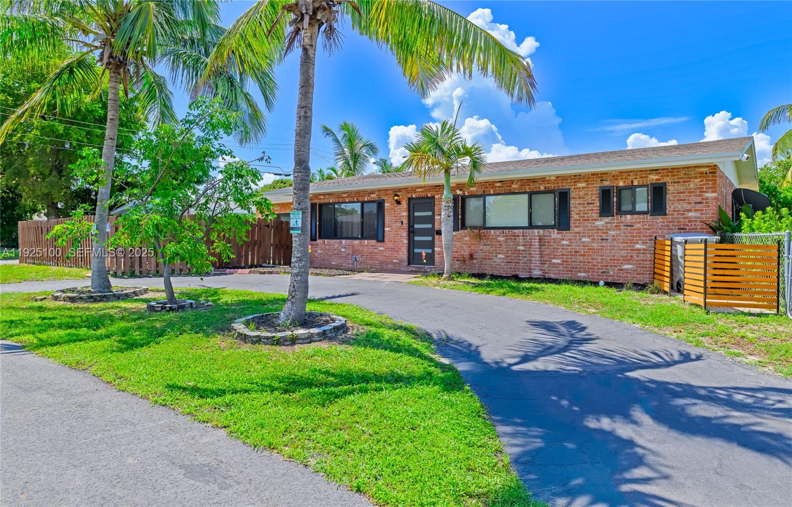 A single-story brick house with a paved driveway and palm trees in the front yard — 1204 NE 7th St, Pompano Beach FL 33060, POMPANO BEACH, FL