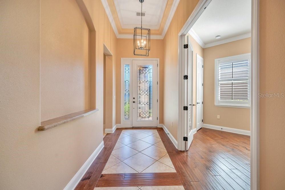 A foyer with tile flooring, a recessed wall niche, and a glass-paneled front door — 4759 LATHLOA LOOP, LAKELAND, FL