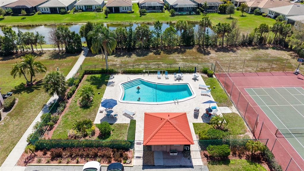 An aerial view shows a swimming pool, a tennis court, and a small pavilion — 6535 DRAW LANE UNIT 85, SARASOTA, FL