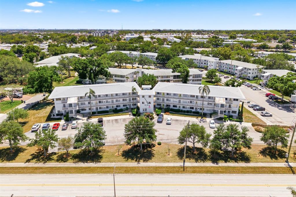 An aerial view of a multi-story apartment complex with parking lots and surrounding trees — 11100 86TH AVENUE UNIT 310, SEMINOLE, FL