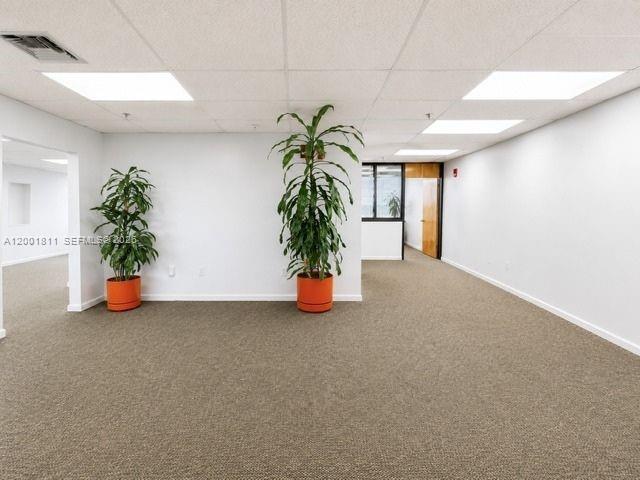 An empty office space features beige carpeting, white walls, and two potted plants — 2600 SW 3rd Ave # 750, Miami FL 33129, MIAMI, FL