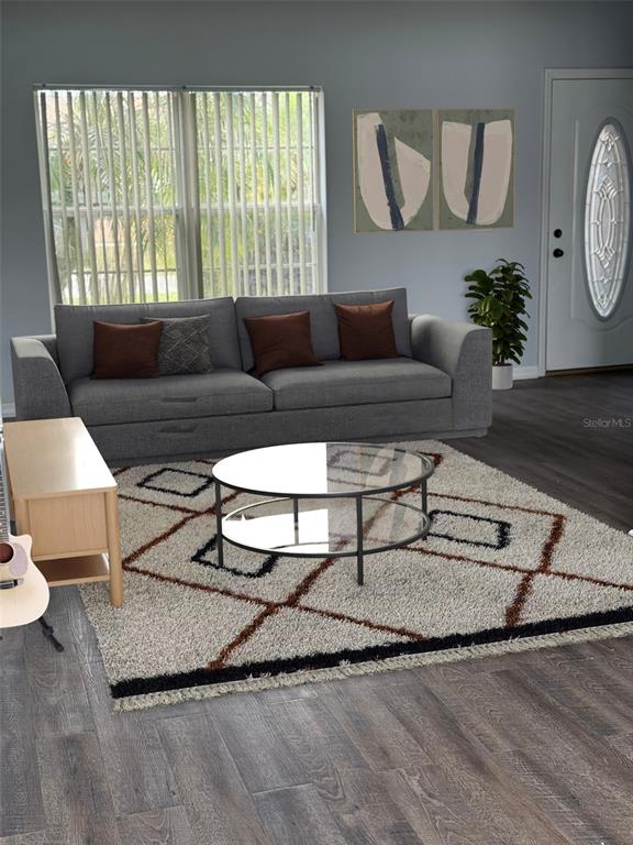This living room features a gray sofa, a glass coffee table, and a patterned area rug — 1117 CAMBOURNE DRIVE, KISSIMMEE, FL