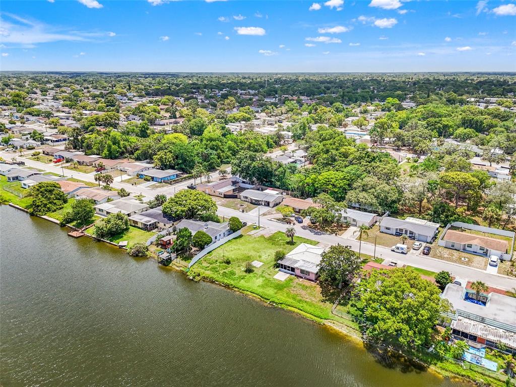 An aerial view shows a residential neighborhood with houses situated along a waterfront — 7211 ASHWOOD DRIVE, PORT RICHEY, FL
