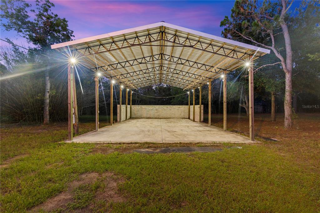 An open-air metal carport with a concrete floor and partial cinder block walls — 17544 GALVESTON STREET, SPRING HILL, FL