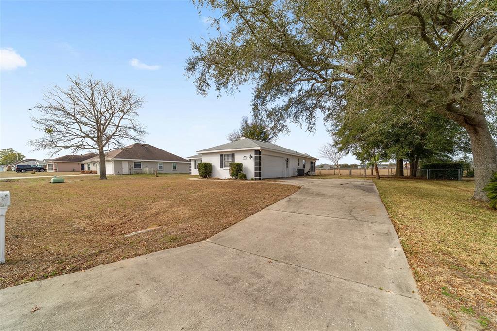 A concrete driveway leads to the side entrance and garage of a single-story house — 3332 NW 50TH COURT, OCALA, FL